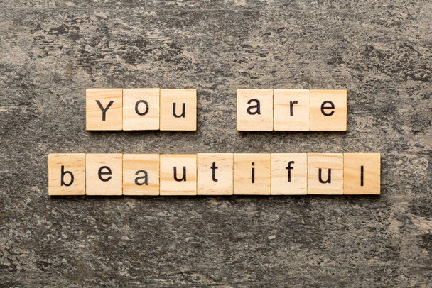 Είσαι όμορφη λέξη γραμμένη σε ξύλο. Είστε όμορφο κείμενο στο τραπέζι τσιμέντου για desing σας, Top view έννοια. - Φωτογραφία, εικόνα