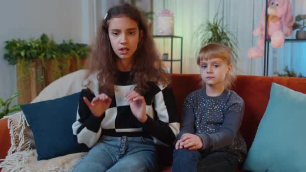 Dziecko i młodsza siostra dziewczynki mówią, że nie trzymają się za ręce skrzyżowane w geście zatrzymania, ostrzegając przed metą, zakazanym dostępem, brakiem komunikacji, niebezpieczeństwem. Rodzeństwo dzieci przyjaciele w domu pokój - Materiał filmowy, wideo
