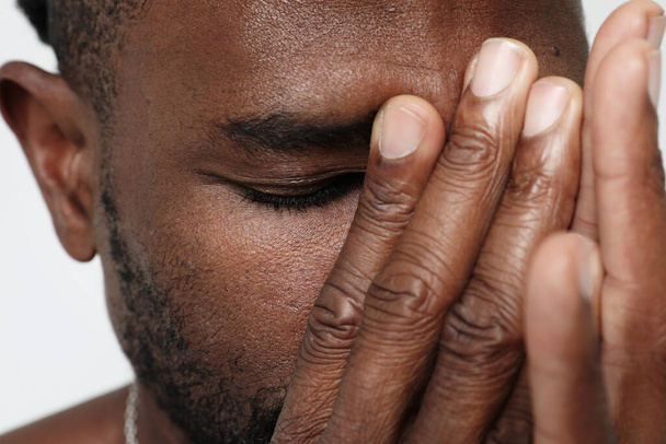 Close-up of serious African American man covering face with his hands. Mock-up. High quality photo. - Fotoğraf, Görsel