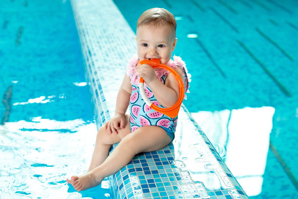 Little girl is laughing in the pool at a swimming lesson. - Foto, immagini