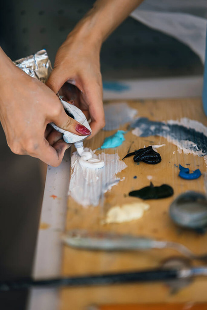 Zavřít na ruce mačkání Malování trubice ve třídě ART - Fotografie, Obrázek