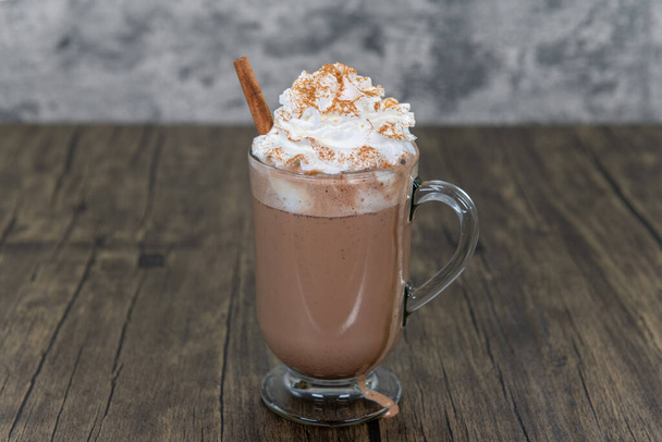 Rich chocolate mocha, topped with whipped cream and cinnamon stick will boost the energy to drink as a morning beverage. - Photo, Image