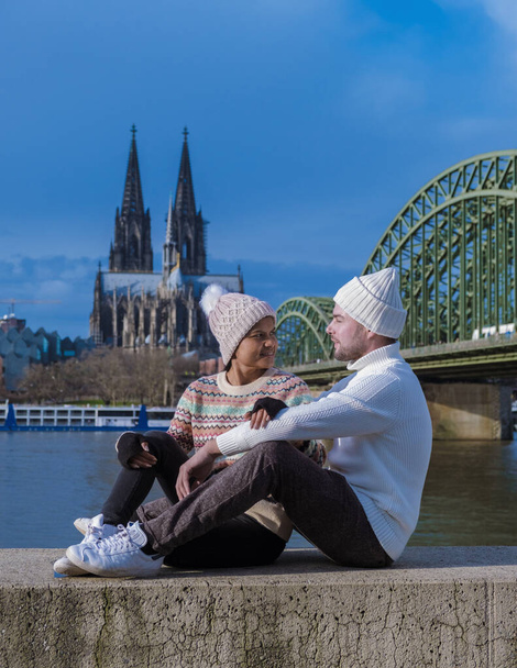 Um casal em uma viagem de cidade em Colônia Alemanha durante o inverno na Europa. Homens e mulheres em frente ao rio olhando para a Catedral Dom de Colônia - Foto, Imagem