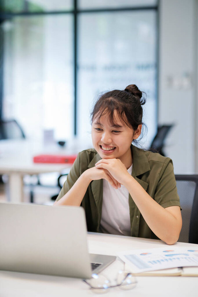 Sorrindo asiático mulher de negócios on-line trabalhando no laptop em casa escritório. Jovem menina asiática estudante ou remoto professor usando computador on-line estudar, treinamento virtual, assistindo online educação webinar em casa escritório. - Foto, Imagem