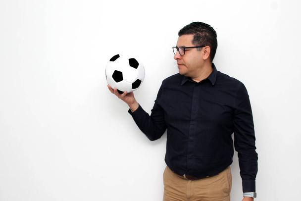 ラティーノの大人のオフィスの男はサッカーボールで非常に興奮している彼は試合を見に行くと彼のチームが勝つ見たいと思います - 写真・画像