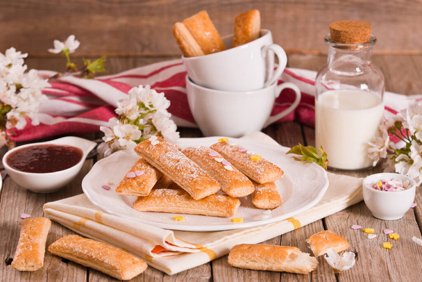Biscotti di pasta sfoglia con zucchero a velo su piatto bianco.. - Foto, immagini
