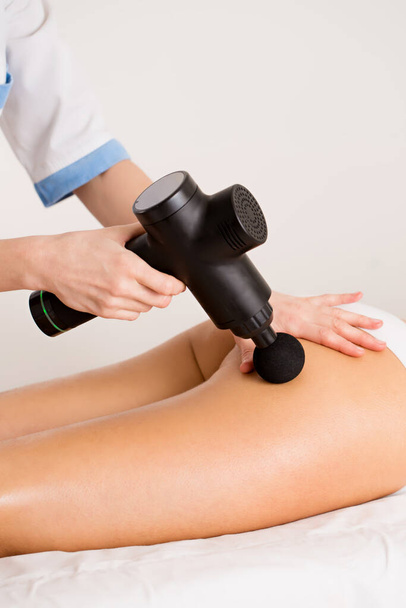 Le massothérapeute donne au patient un drainage lymphatique et un massage anti-cellulite avec un outil de massage sur les hanches - Photo, image