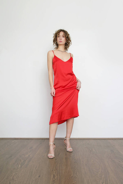 Kobieta w czerwonej jedwabnej satynowej sukience, studio shot. - Zdjęcie, obraz