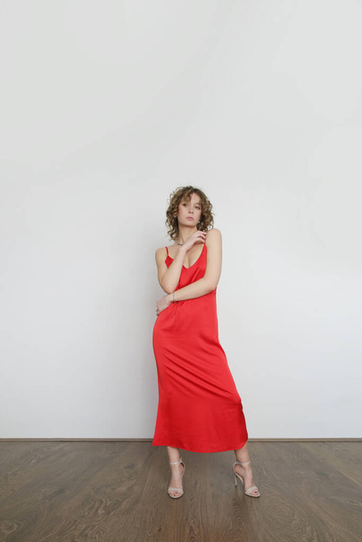 Woman in red silk satin camisole dress, studio shot. - Foto, afbeelding