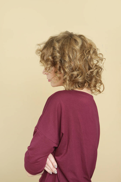 オーガニックコットンを使用したバーガンディシャツを着た若い女性モデルのスタジオ写真。快適な持続可能なファッション. - 写真・画像
