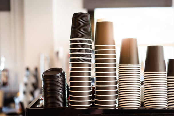 Many of a disposable paper coffee cups stacked on the coffee machine in coffee shop. - Φωτογραφία, εικόνα