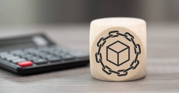 Blocco di legno con simbolo di blockchain concetto e calcolatrice sullo sfondo - Foto, immagini