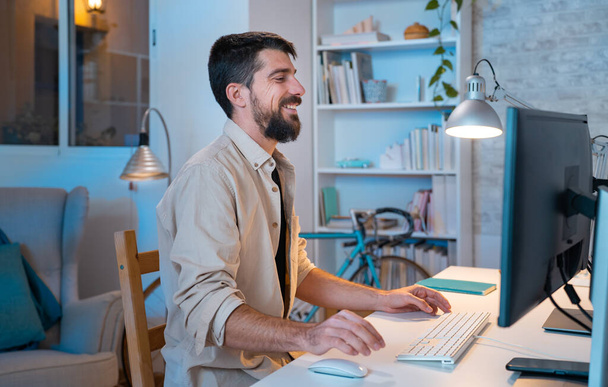 Young creative entrepreneur happy smiling while working in his modern workspace at home. - Freelance guy small business, work from home concept. High quality photo - 写真・画像