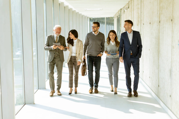 Group of corporate business professionals walking through office corridor on a sunny day - Fotografie, Obrázek
