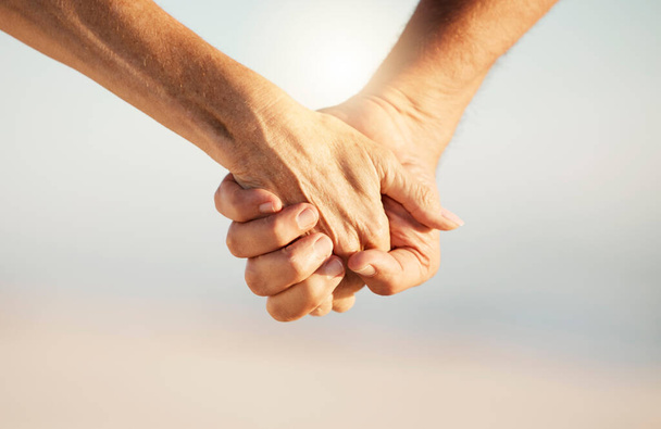 Detailní záběr staršího páru držícího se za ruce na pláži. Starší pár, držící se za ruce u oceánu. Ruce ženatého staršího páru na společné dovolené. Starší pár drží ruce na pláži. - Fotografie, Obrázek