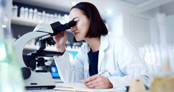 Scientist woman, microscope and lab with writing, book and development of vaccine, cure or medicine. Asian medical expert, science tools and laboratory research for pharmaceutical career in Tokyo. - Photo, Image