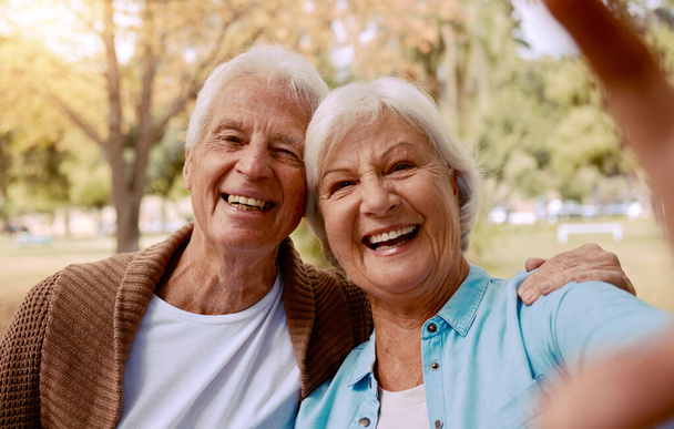Liefde, glimlach en selfie met oud koppel in park voor hechting, ontspanning en genegenheid samen. Pensioen, natuur en gelukkig met portret van man en vrouw in de tuin voor geluk, zomer en relatie. - Foto, afbeelding