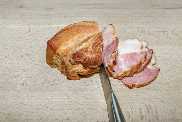 Bacon defumado fatiado em uma tábua de madeira. - Foto, Imagem