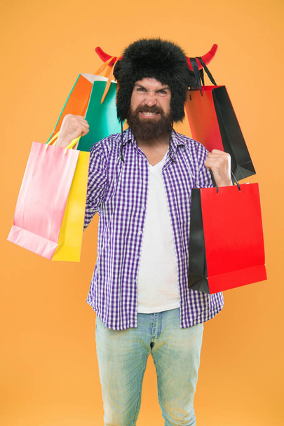 Full packages of items. Man mad face wear hat bull with horns. Hipster shopping addicted or shopaholic. Shopping concept. Guy shopping sales season discount. Animal and vet store. Wild about shopping. - Foto, Imagen