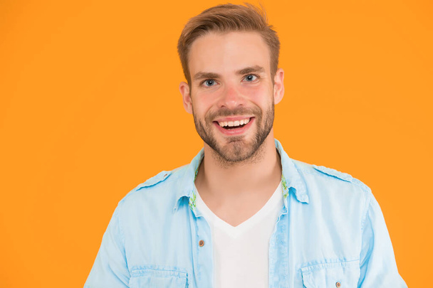 positive cheerful man smiling wear denim style outfit over yellow background, happiness. - Foto, afbeelding