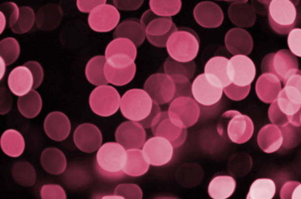 Abstract background image with bokeh effect. Many brightly ed circular shapes on a dark background. Image toned in Viva Magenta, color of the 2023 year - Fotó, kép