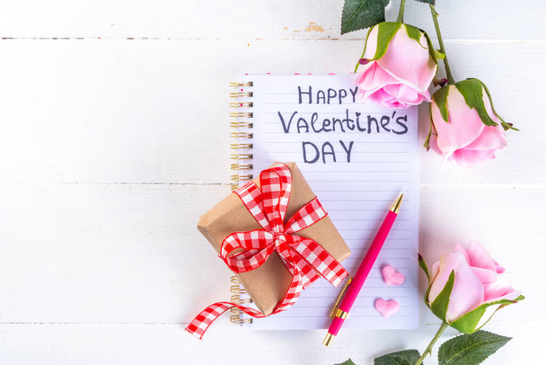 8 Μαρτίου Ημέρα της Γυναίκας, Ημέρα του Αγίου Βαλεντίνου φόντο ευχετήρια κάρτα με τριαντάφυλλα λουλούδι μπουκέτο, κουτί δώρου με κόκκινη κορδέλα, καρδιά σχήματα διακόσμηση, σε λευκό ξύλινο τραπέζι top view αντίγραφο χώρου  - Φωτογραφία, εικόνα