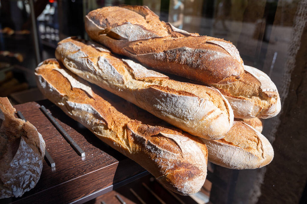 French bakery in Lyon, many fresh baked baguettes breads ready for sale close up - Photo, Image