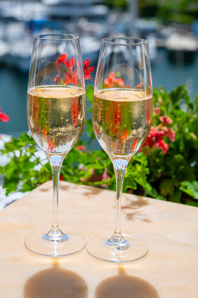 Przyjęcie noworoczne, picie francuskiego szampana musującego w kieliszkach w porcie jachtowym Port Grimaud niedaleko Saint-Tropez, wakacje na Riwierze Francuskiej, Francja - Zdjęcie, obraz