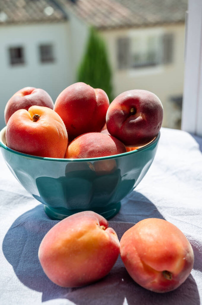 Mísa s červenými zralé sladké meruňky ovoce, sklizeň ve Vaucluse, Provence, Francie a pohled na provensálské vesnice - Fotografie, Obrázek