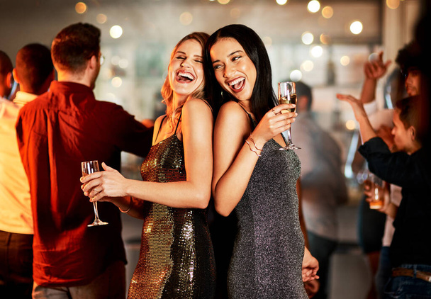 Друзі, святкування Нового року та вечірки, напої та щаслива посмішка з танцями, музикою та жіночими нічними соціальними мережами. Жінки, сміються і святкують на заході з людьми, п'ють алкоголь і нічний клуб
. - Фото, зображення