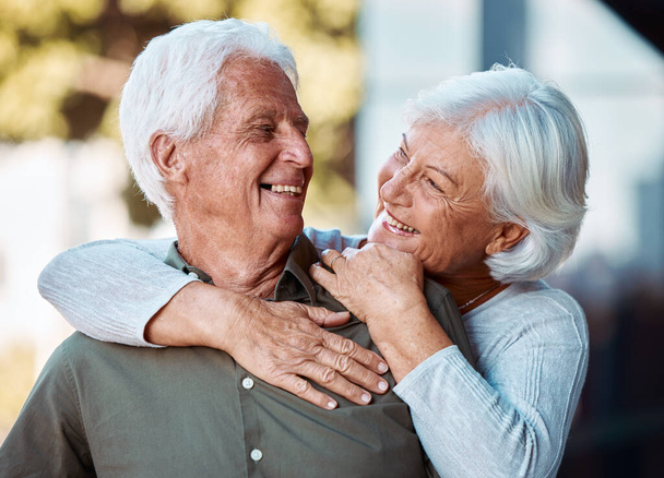 幸福のための愛、高齢者のカップルと抱擁、退職と屋外での結合。ロマンチックで年配の男性と高齢者の女性は、笑顔との関係のために愛し、リラックスする記念日とウェルネス - 写真・画像