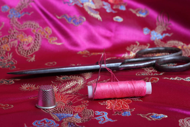 Cívka z růžového vlákna a náprstek na ročníku růžový satén - Fotografie, Obrázek