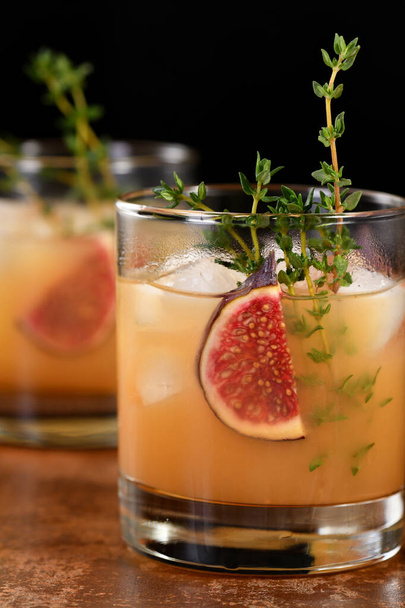 Bourbon zure cocktail met vijgenkruiden, citroensap en siroop. Makkelijk te maken, maar zo lekker. Garneer met vijgen en tijm. - Foto, afbeelding