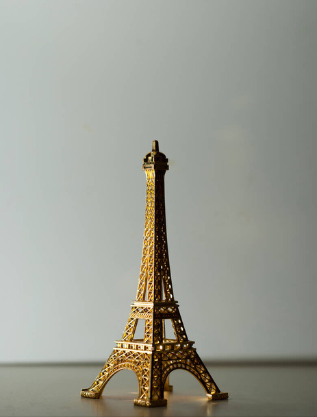 Replica Eiffel Tower in shiny gold on white background in vertical - Photo, Image