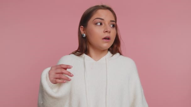 Excited amazed woman 20s in sweater touching head and showing explosion, looking worried and shocked, professional burnout. Looking surprised wow girl isolated alone on pink studio wall background - Footage, Video