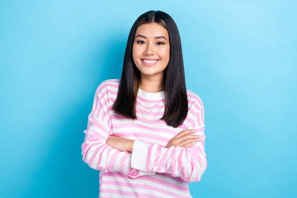 Photo of shiny confident young lady wear striped sweater arms folded smiling isolated blue color background. - Foto, afbeelding