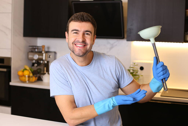 Porträt eines hübschen jungen Mannes mit Rohrkolben in der Küche - Foto, Bild