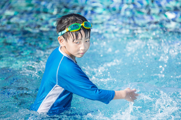 Petit garçon asiatique jouer dans la piscine avec maillot de bain
 - Photo, image