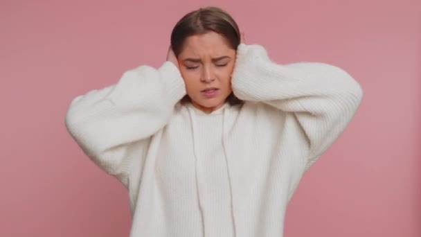 Dont want to hear and listen. Frustrated annoyed irritated young pretty woman covering ears, gesturing No, avoiding advice ignoring unpleasant noise loud voices. Adult girl on studio pink background - Footage, Video