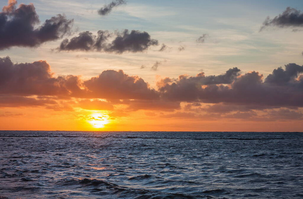 海で美しい日の出。大西洋で夜明け。太陽は海に反射される。上昇する太陽の背景にヤシの木。熱帯の日の出だ。ドミニカ共和国 - 写真・画像
