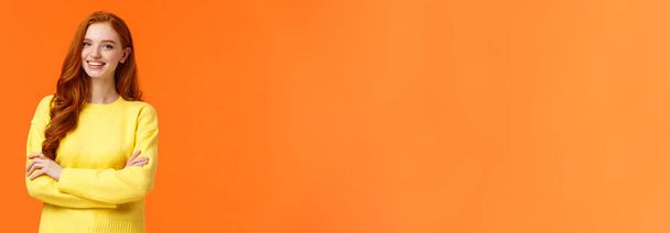 Bedrijfs-, e-commerce- en mensenconcept. Moderne student, roodharige meisje leren Het, digitaal ontwerp op de universiteit, kruis armen over de borst met zelfverzekerde, assertieve houding, glimlachen gelukkig, oranje achtergrond. - Foto, afbeelding