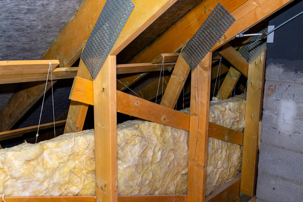 Isolation des murs et du plafond dans le grenier en laine minérale entre les fermes, liée par une ficelle de polypropylène. - Photo, image
