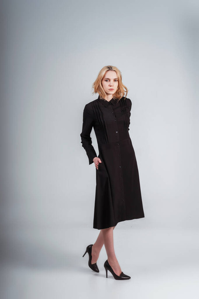 girl in a black dress on a white background. photo of a girl in full growth in a black dress. photoshoot of black clothes with a model - 写真・画像
