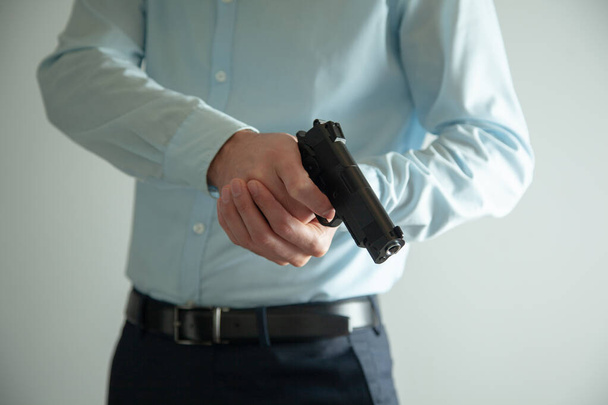man hand holding gun on grey background - 写真・画像