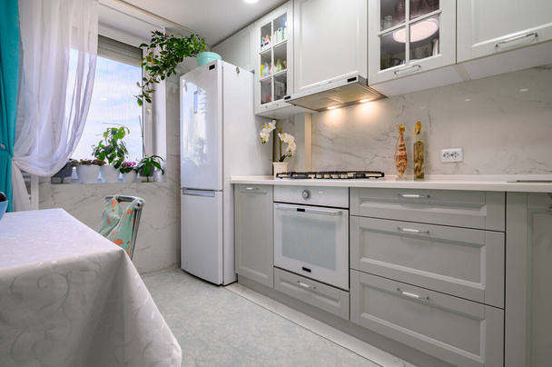 Новий світло-сірий сучасний добре спланований кухонний інтер'єр після ремонту
 - Фото, зображення