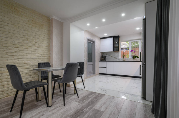 Nowy duży nowoczesny, dobrze zaprojektowany biały kuchnia i jadalnia wnętrze po remoncie w studio apartamencie - Zdjęcie, obraz