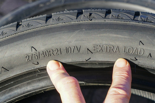 Vue latérale du pneu neuf avec indication de la largeur, de la hauteur et du diamètre de la roue ainsi que des indices de vitesse et de charge - Photo, image