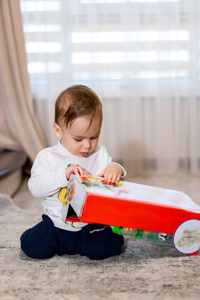 Little boy opening his birthday gift. Baby with new toy - Zdjęcie, obraz