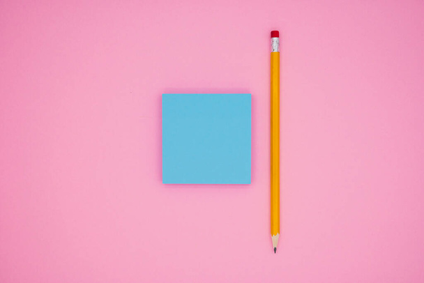 Lápiz amarillo y notas adhesivas en blanco, sobre fondo rosa. El concepto de trabajo de oficina, papelería. - Foto, imagen