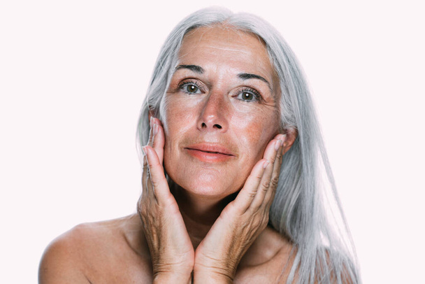 Image of a beautiful senior woman posing on a beauty photo session. Middle aged woman on a colored background. Concept about body positivity, self esteem and body acceptance - Zdjęcie, obraz